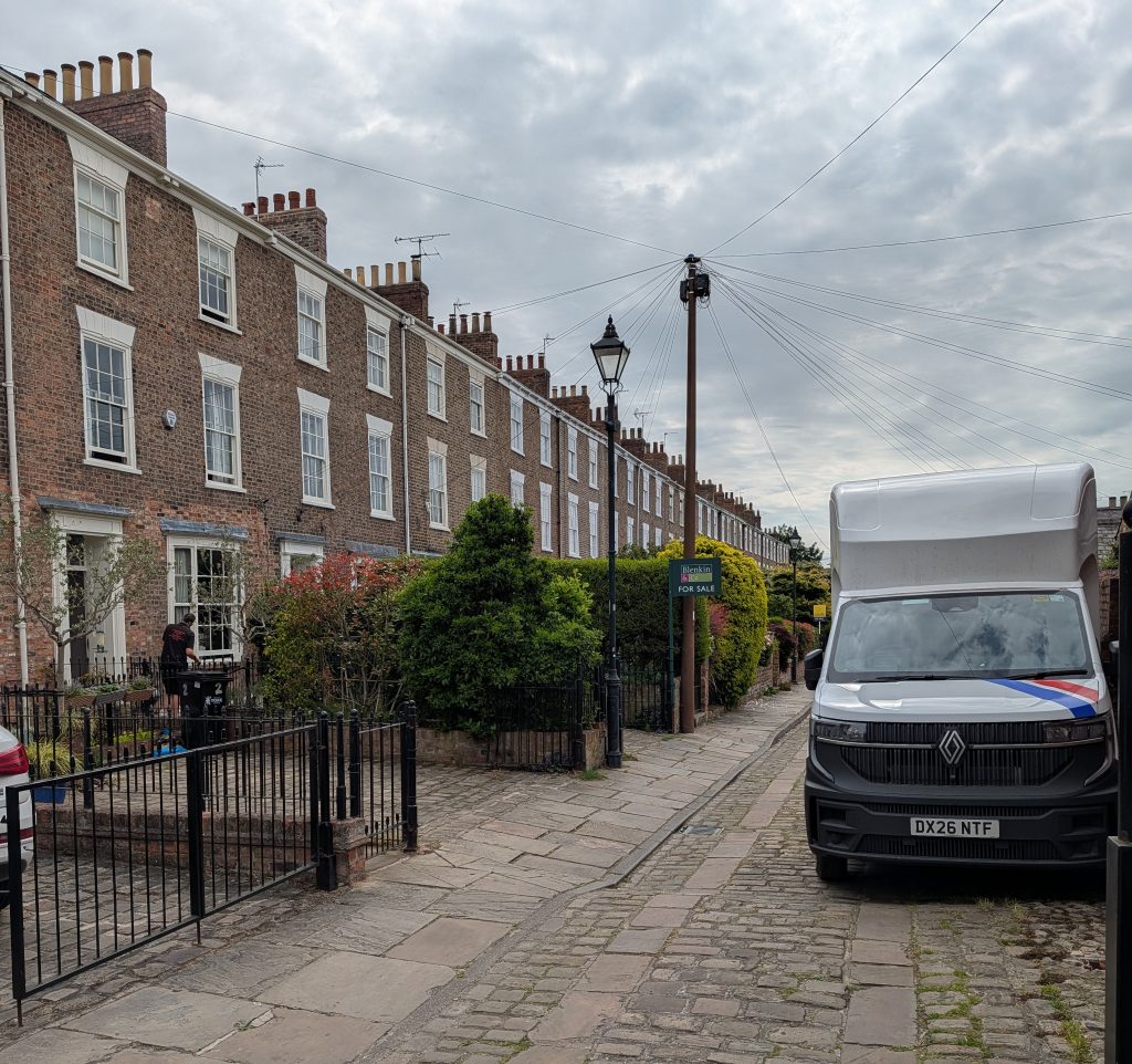 A removals van outside a long row of houses | A&M Removals