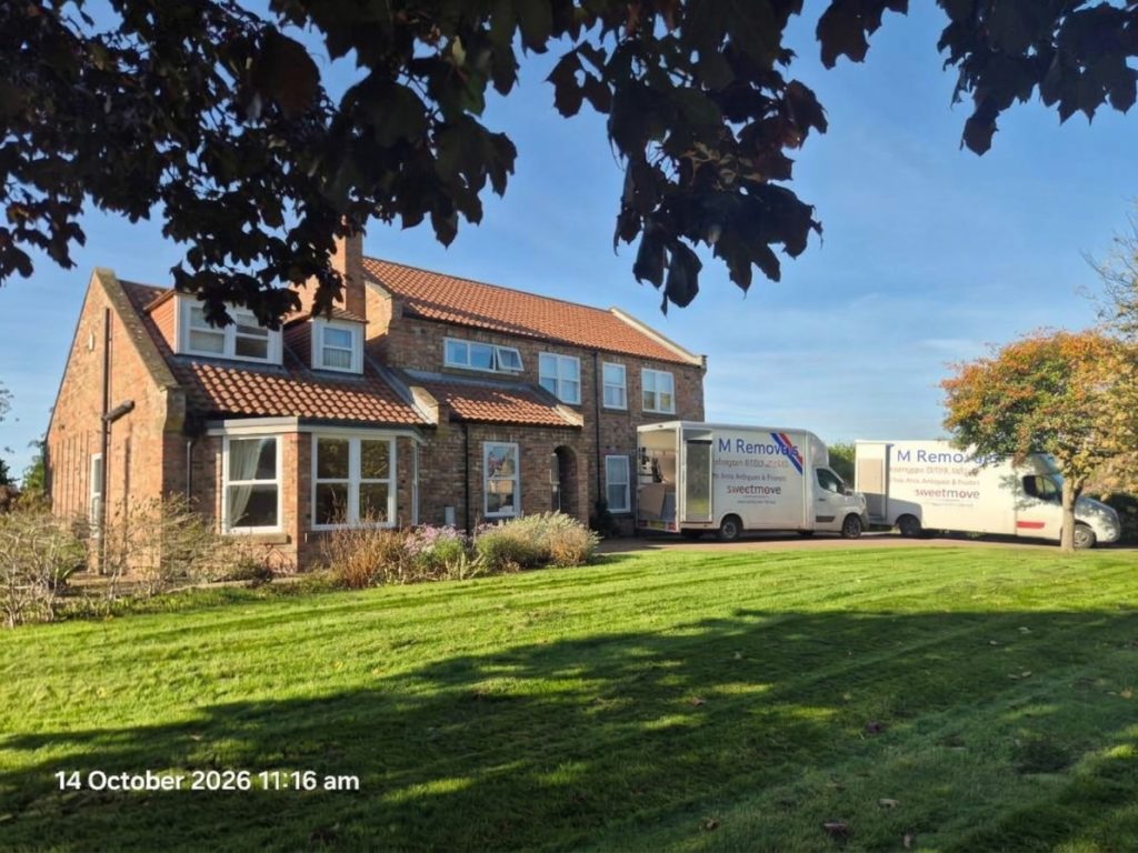 A&M Removals van outside a house with a large garden